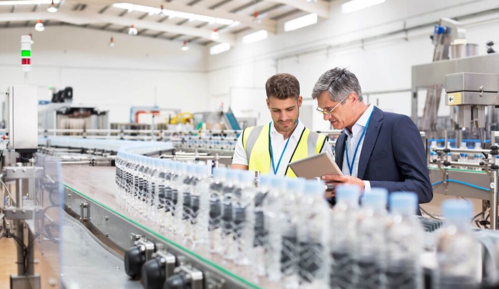 two men reviewing a food production line