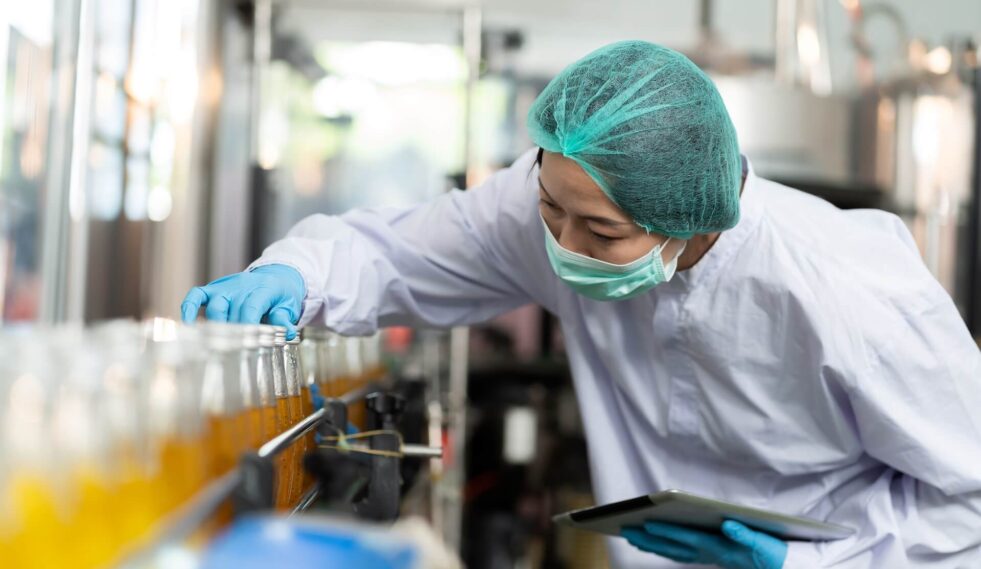 woman reviewing a bottling production line