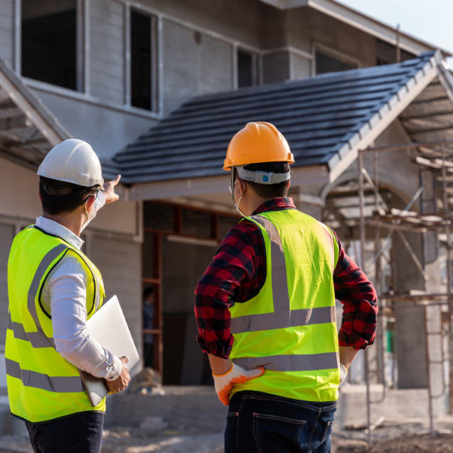 two construction workers building a house