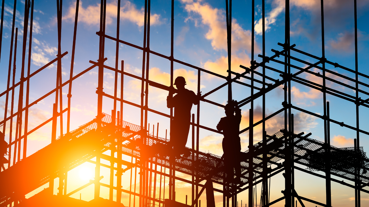 Construction workers on construction site at sunset